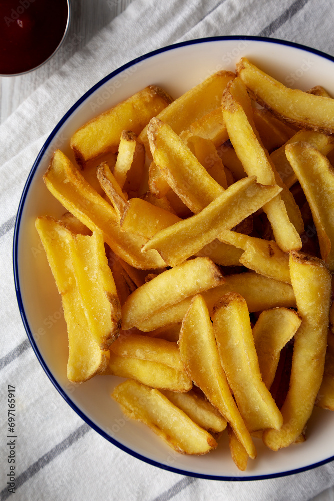 Homemade French Fries on a Plate on a white wooden background, top view. Flat lay, overhead, from above. Homemade French Fries on a Plate on a white wooden background, top view. Flat lay, overhead, from above.