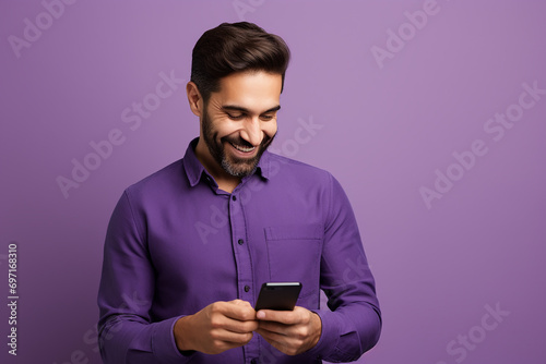 man looking at phone standing isolated on purple background © Uzair