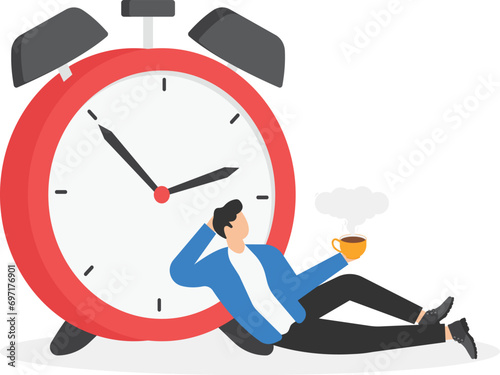 Sitting businessman with a cup of coffee beside the alarm clock.

