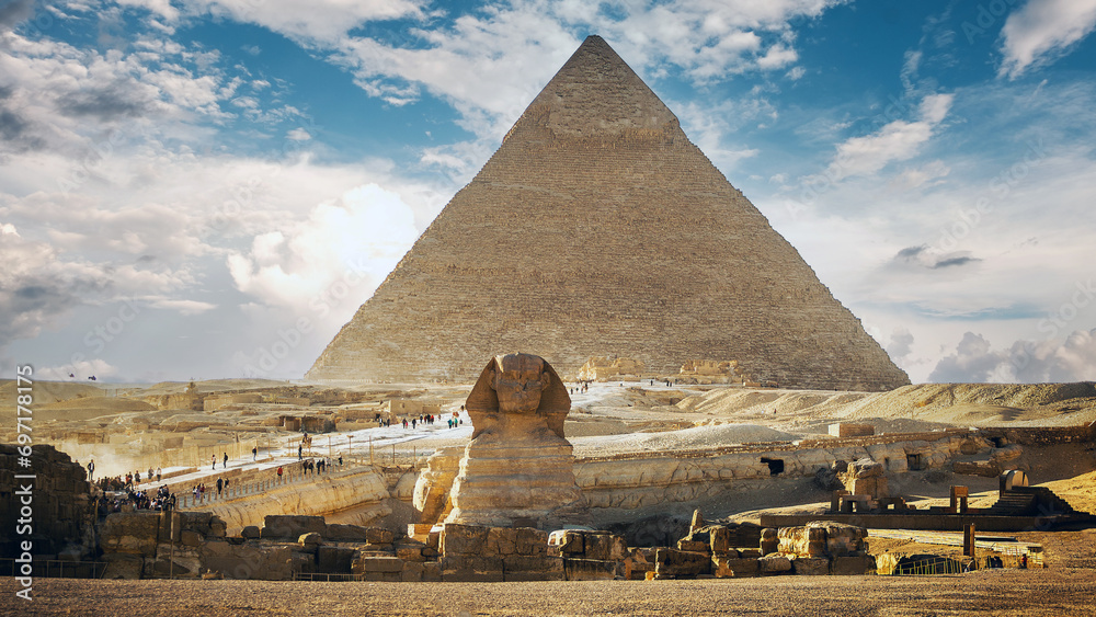 Landscape with Egyptian pyramids, Great Sphinx and silhouettes Ancient symbols and landmarks of Egypt for your travel concept to Africa in golden sunlight. The Sphinx in Giza pyramid complex at sunset - obrazy, fototapety, plakaty 