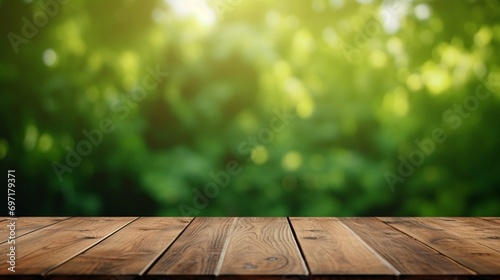 Table top made of empty wood with a blurred abstract green background from a house and garden. For product showcase montage © juni studio