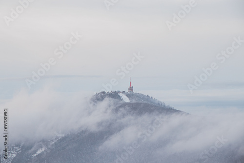 Highest peak of Beskydy mountains Lysa hora under the morning fog and white snow cover. Winter months on planet Earth