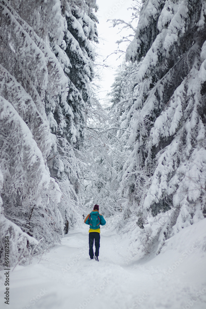 Traveller walks around the snowy landscape. Winter walk through untouched landscape in Beskydy mountains, Czech Republic. Hiking lifestyle