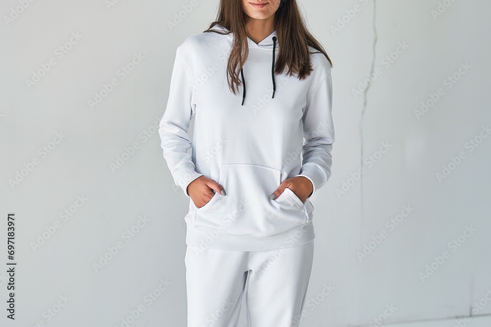 A girl in a white hoodie poses for a mock-up design. A fashion template for print and branding. A studio shot of a young woman in a casual pullover. A mock-up template of a white hoodie. A girl in a white hoodie poses for a mock-up design. A fashion template for print and branding. A studio shot of a young woman in a casual pullover. A mock-up template of a white hoodie.