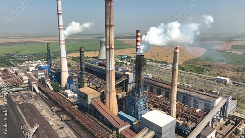 Aerial view of power plant chimneys, industrial area. Close-up of a smoking chimney. Old large thermal power plant in Europe. The production of electricity from coal pollutes the air. Factory landscap
