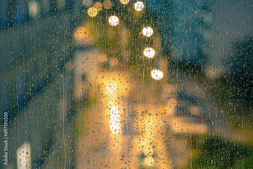 Fototapeta Naklejka Na Ścianę i Meble -  Water drops on the window pane, glass. Lights of the city. Bokeh - abstract vivid colorful background. 