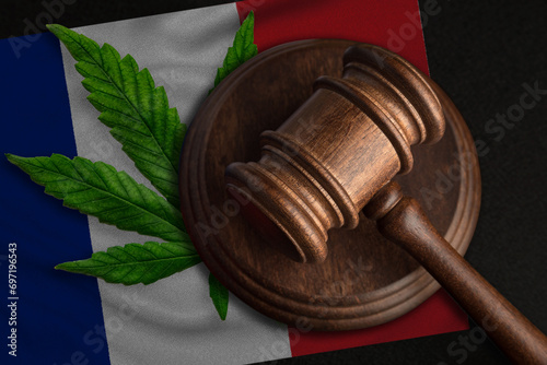 Flag of France and justice wooden gavel with cannabis leaf. Illegal growth of cannabis plant and drugs spreading.