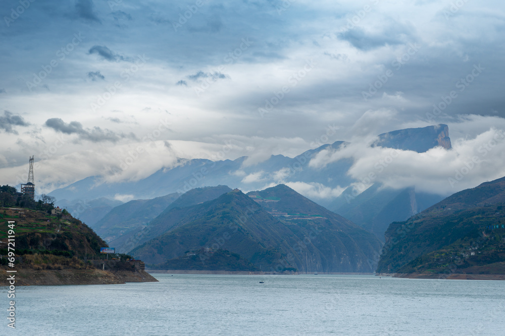 A serene view of the Yangtze River surrounded by misty mountains, captured in Longhui Flower Valley, Fengjie County, China on March 17, 2018.