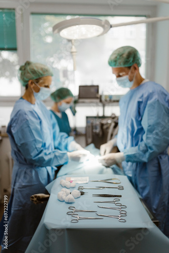 Surgical equipment arranged on table with animal surgeons in background at hospital