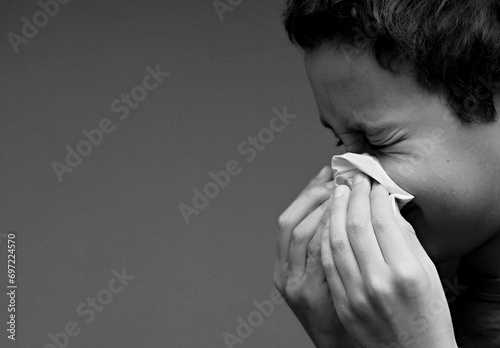 catching the flu child blowing nose after catching a cold with grey background with people stock photo photo