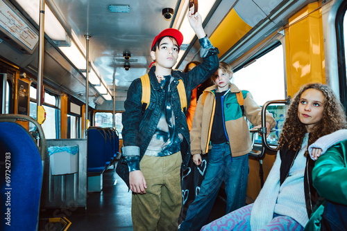 Multiracial boys and girls traveling by tram during weekend photo