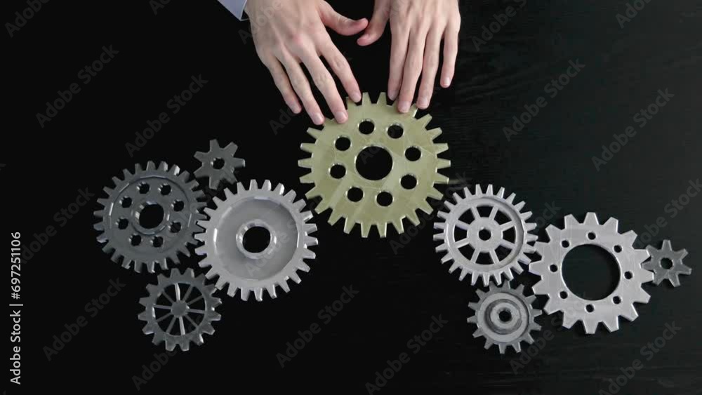 Man hands putting a cogwheel into a common mechanism. Abstract background. Concept of the own business and partnership. Man hands putting a cogwheel into a common mechanism. Abstract background. Concept of the own business and partnership.
