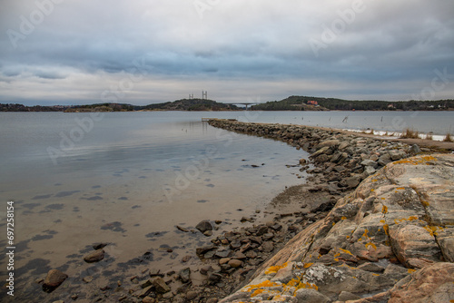Landscape shot on a coast in winter with a view of the Tjörnbron cable bridge in the bay of Stenungsund in Sweden photo
