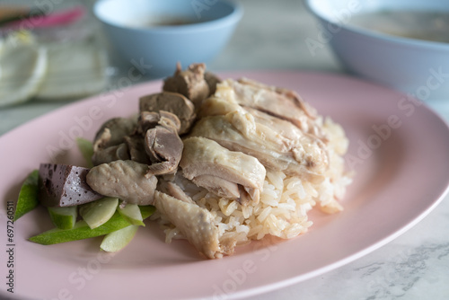 Boiled chicken, offal with cucumber sliced eating with rice and spicy or sweet sauce.