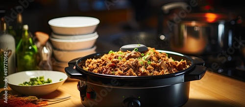 Cooking traditional Eastern pilau with meat in a modern multicooker on a kitchen table.