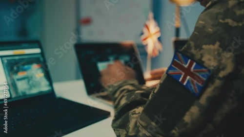 United Kingdom soldier working with gathered intelligence copying data on laptop photo