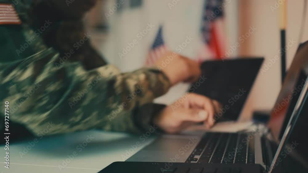 Close-up of U.S. military officer typing laptop in office, controlling mission