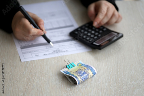 Accountant start to fill Iranian tax form on office table. Taxation period and annual taxpayers routine in Iran photo