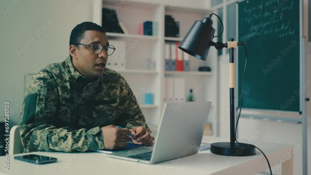 African American army teacher in glasses having online video lesson with cadets