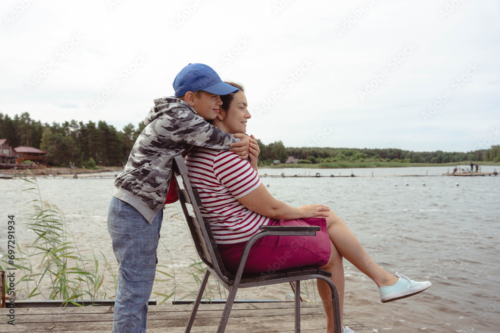 Heartwarming Moment: Son Embracing Mother on a Family Lake Camping Trip