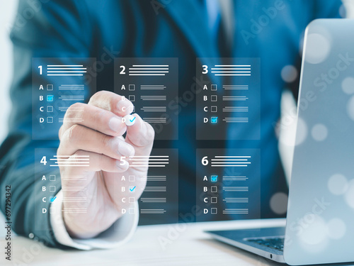 assessment survey online. Businessman with evaluating questionnaire on online laptop computer. choose correct answer in test, questions test, online exam, quiz knowledge, filling out an survey form.