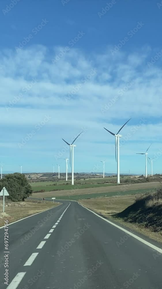 Line of Massive Wind Turbines, subjective visit from a car. Concept of ecological transition renewable energy climate change green energy. There is no planet b. Green energy choice concept.