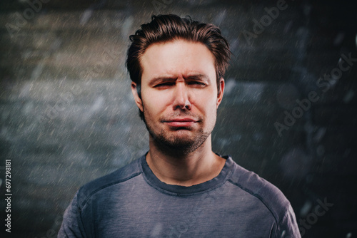 Young handsome man crying portrait in the rain photo