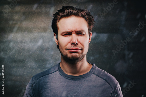 фотографія Young handsome man crying portrait in the rain
