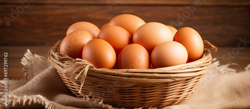 Close-up of brown chicken eggs in a wooden basket, organic protein, space for text, rustic products.