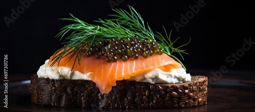 Smoked salmon, cream cheese, and caviar on pumpernickel bread with dill. photo