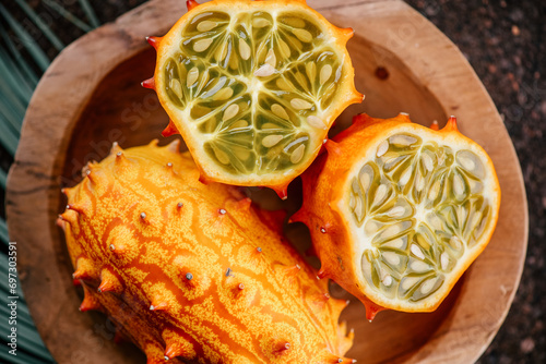 Kiwano fruit or Horned melon close up. Fresh and juicy African horned cucumber or jelly melon, hedged gourd liana exotic fruits. Top view  photo