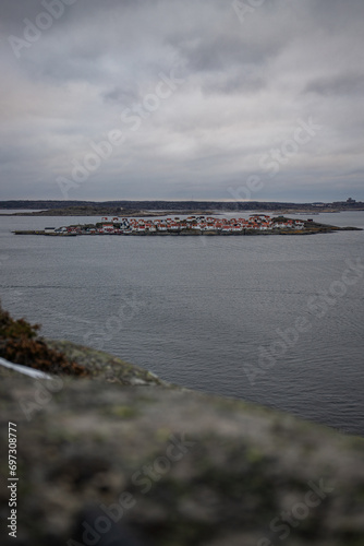 Landscape shot with a view of an island. Taken from a barren rock, you can see over the coast and the sea to the small island of Astol, Rönnäng, Sweden, which is built with typical Swedish houses photo