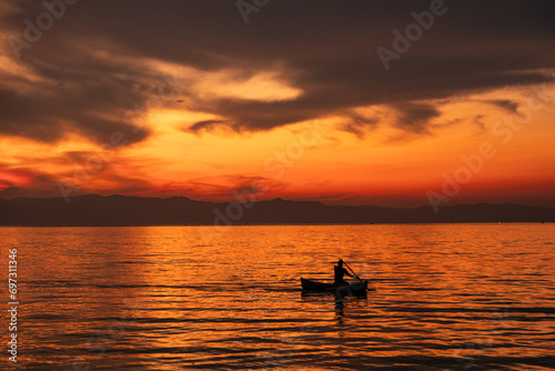Fisherman in a dugout canoe at sunset in Lake Malawi in Cape Maclear  Malawi
