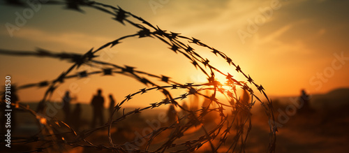 Barbed wire against the backdrop of refugees
