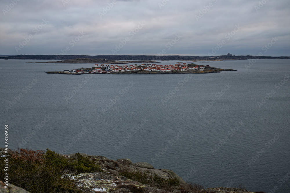 Landscape shot with a view of an island. Taken from a barren rock, you can see over the coast and the sea to the small island of Astol, Rönnäng, Sweden, which is built with typical Swedish houses