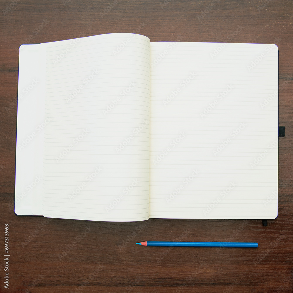 Notebook and pencil on a beautiful background in a large photo studio Notebook and pencil on a beautiful background in a large photo studio