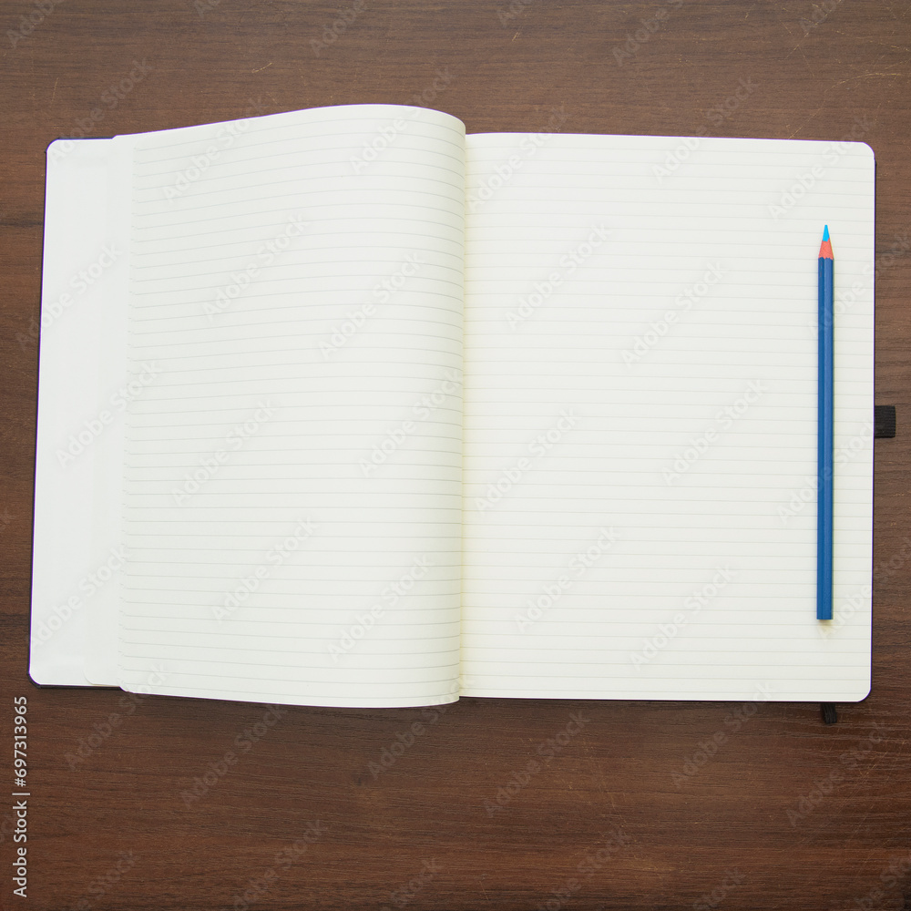 Notebook and pencil on a beautiful background in a large photo studio Notebook and pencil on a beautiful background in a large photo studio