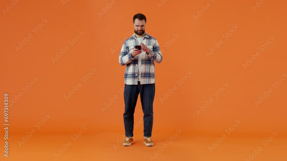 Bearded man chooses goods in online store using mobile phone Bearded man chooses goods in online store using mobile phone