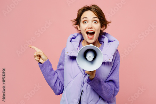 Young woman wears purple vest sweatshirt casual clothes hold in hand megaphone scream announces discounts sale Hurry up point aside isolated on plain pastel light pink background. Lifestyle concept.