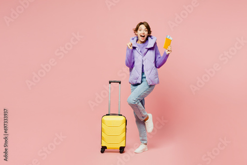 Traveler young woman wear vest casual clothes hold bag passport ticket isolated on plain pastel pink background. Tourist travel abroad in free spare time rest getaway. Air flight trip journey concept. #697333937