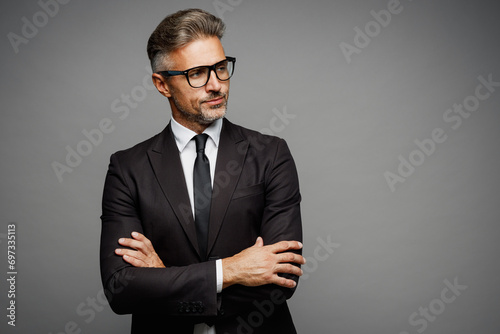 Adult successful employee business man corporate lawyer wears classic formal black suit shirt tie work in office hold hands crossed folded look aside isolated on plain grey background studio portrait.