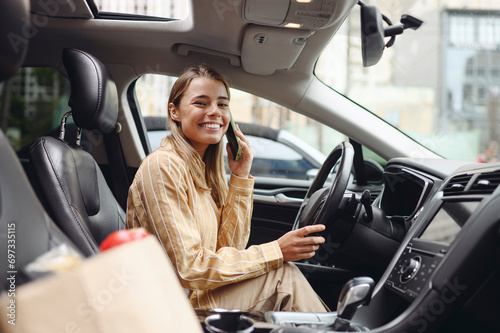 Young customer woman wear casual clothes talk mobile cell phone driving car with paper bag of goods after shopping buying products at supermaket store grocery shop hypermarket Purchasing food concept