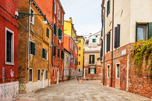 cozy narrow street with colorful houses in Venice early in the morning. Journey