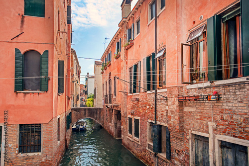 narrow canal in venice with water taxi in the morning