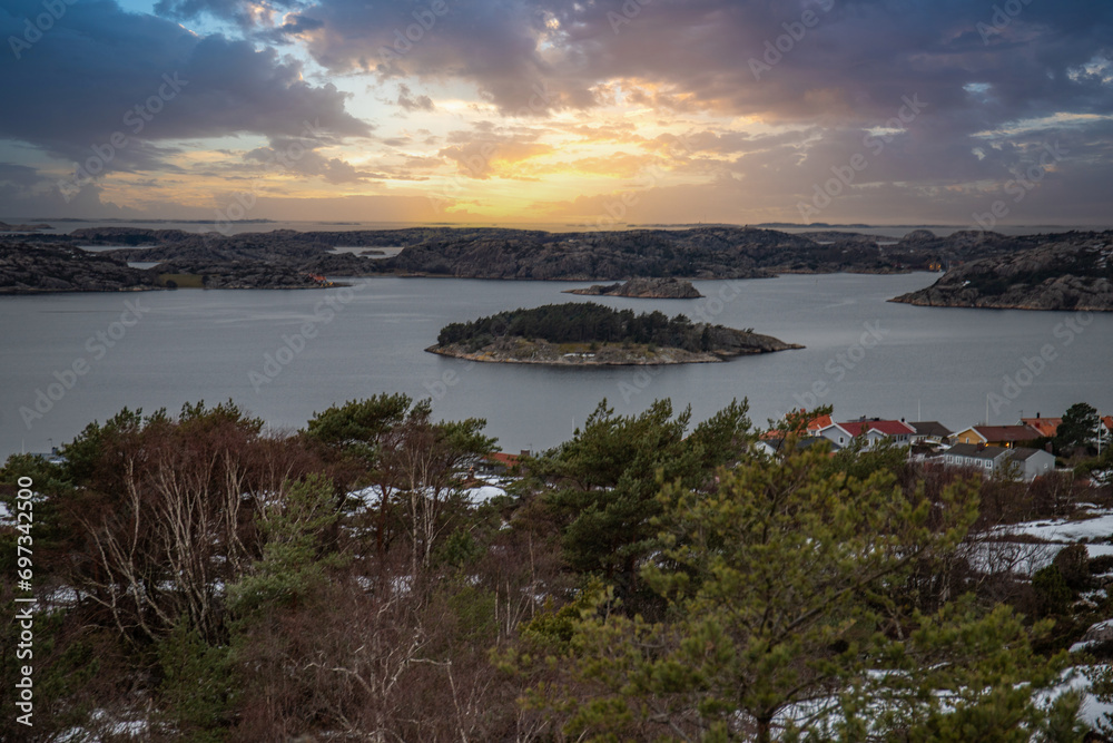 View over a stony coastal landscape in winter. Snow, ice and withered heather. Landscape shot in the town of Fjällbacka on the west coast of Sweden