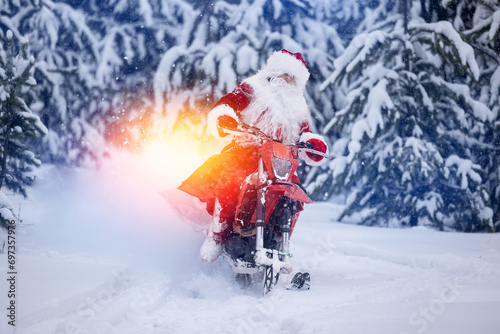 Santa Claus in red cloth riding on snow bike, motorcycle with ski background snow forest. Concept delivery gift for Christmas holiday. photo