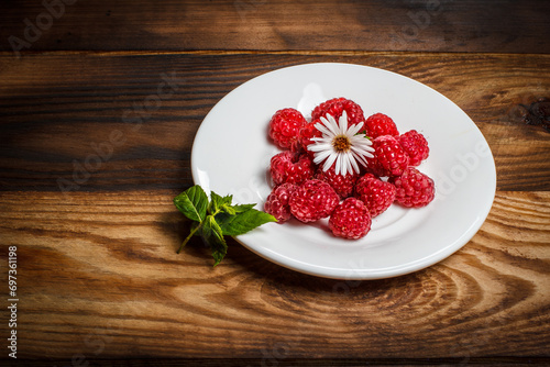Red raspberries lie on a plate, raspberries for dessert