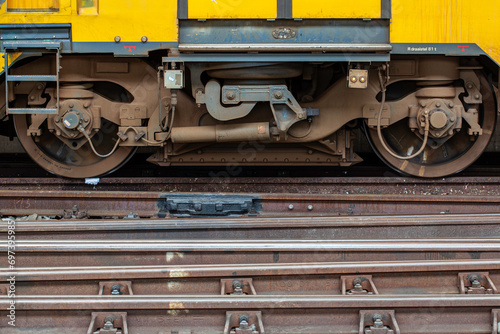 Bilde på lerret Close Up of train boogie resting in the station with railways on the foreground