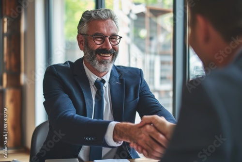 Smiling middle aged business man handshaking partner making partnership collaboration agreement at office meeting, hr manager and new worker shake hands recruiting at job interview. Welcome onboarding photo