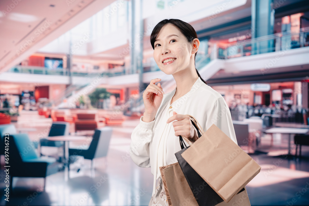 ショッピングモールで福袋を購入する若い女性 ショッピングモールで福袋を購入する若い女性